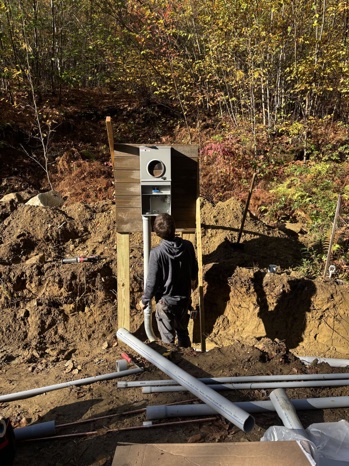 A. Pro Electric crew member setting the meter pedestal with conduit laid out in the trench