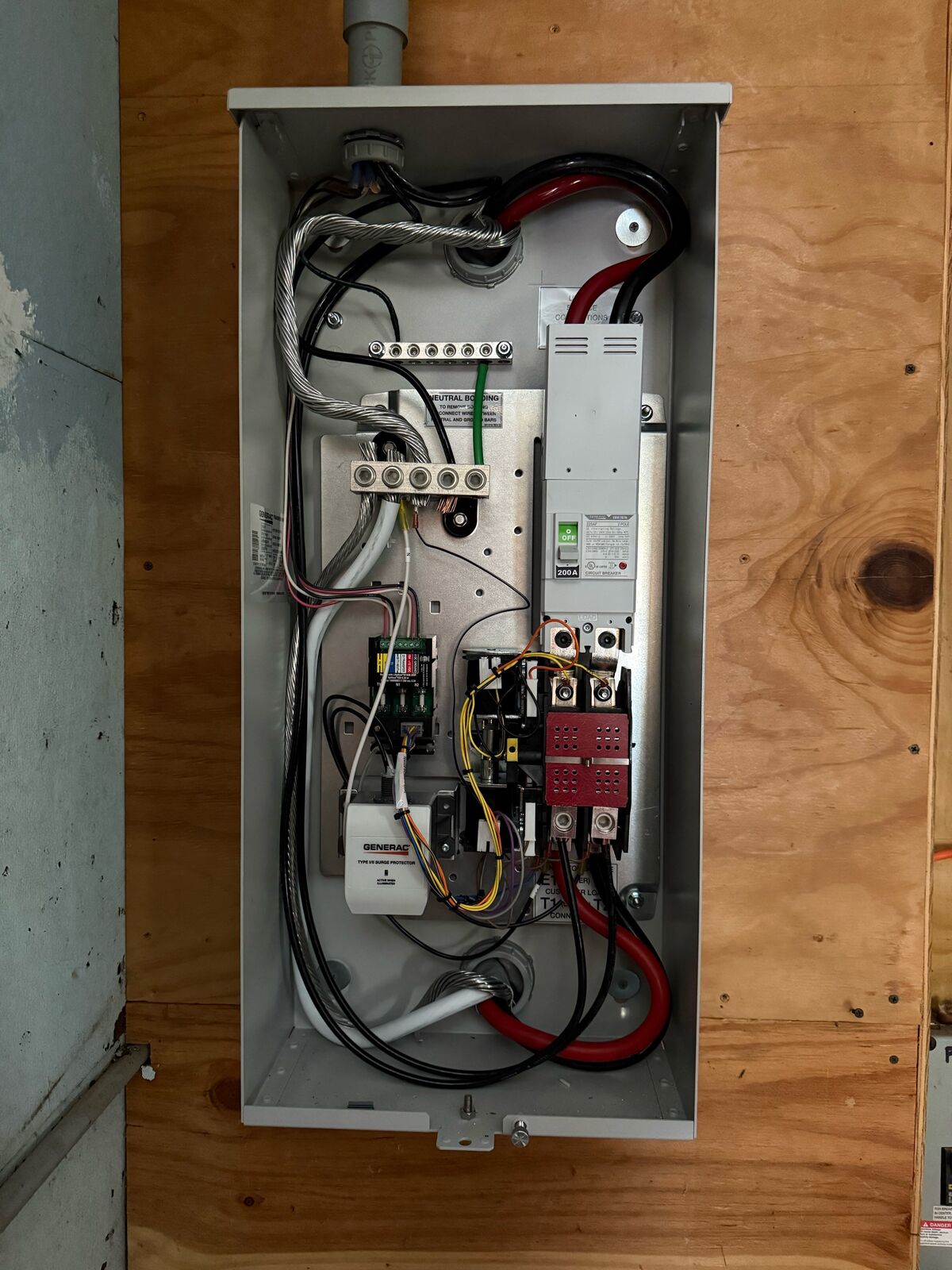 Generac 200 amp automatic transfer switch wired and open on a plywood backboard for a 14kW standby generator in Weare, NH