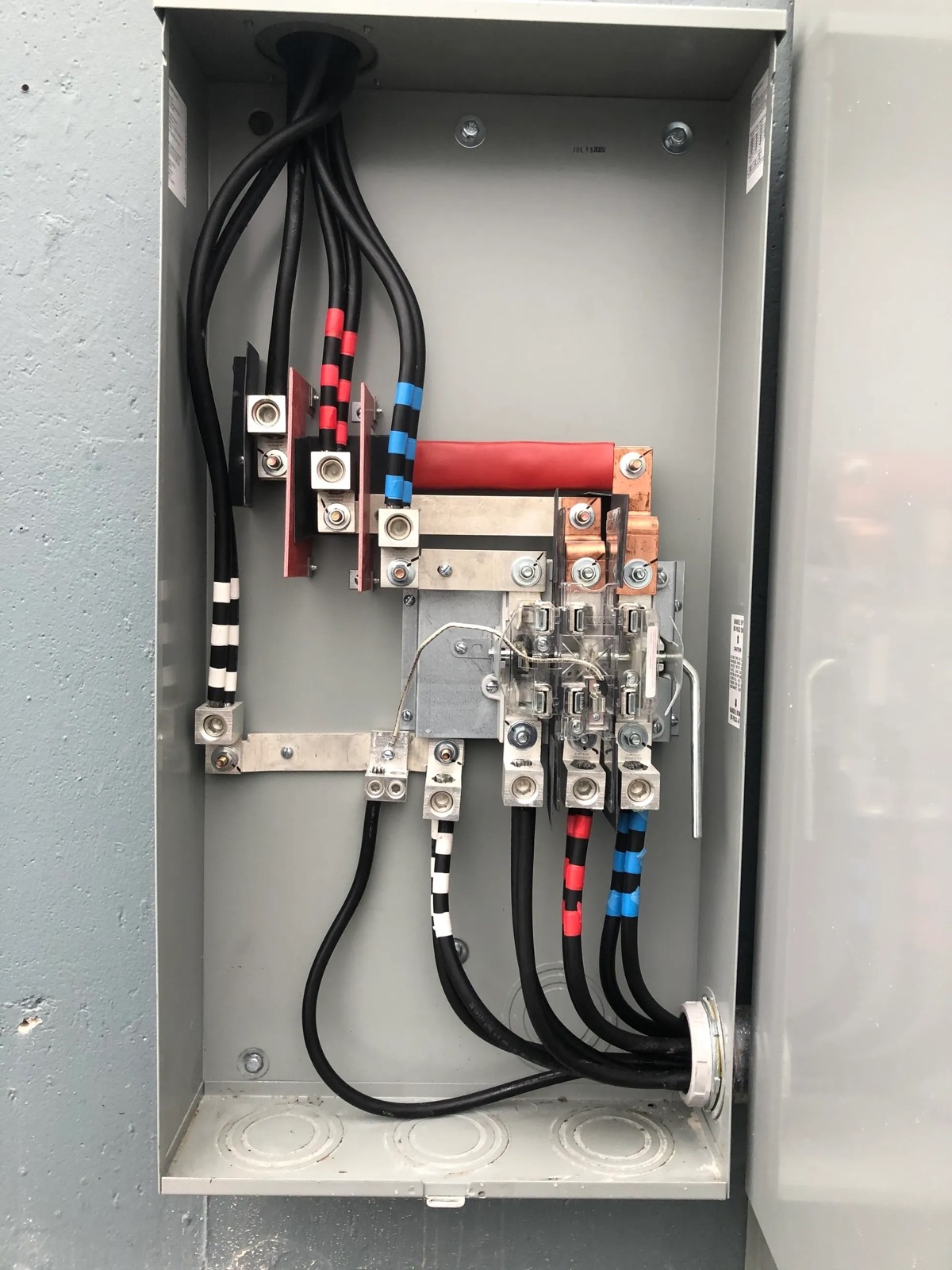 Phase-taped conductors landed on distribution lugs inside a panel