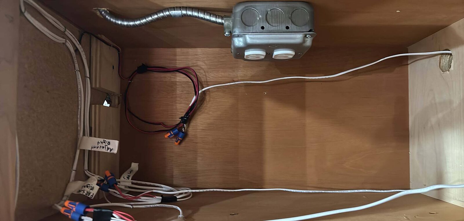 Junction box and hand-labeled fixture conductors made up inside a cabinet
