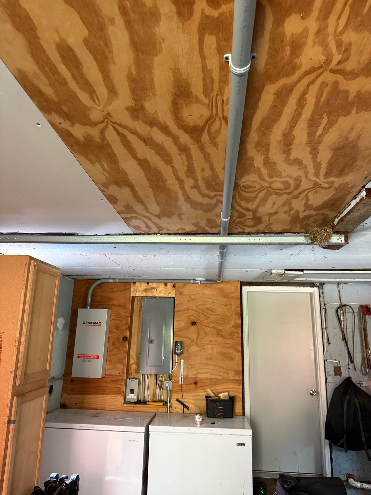 New transfer switch mounted beside the breaker panel, conduit run along the ceiling